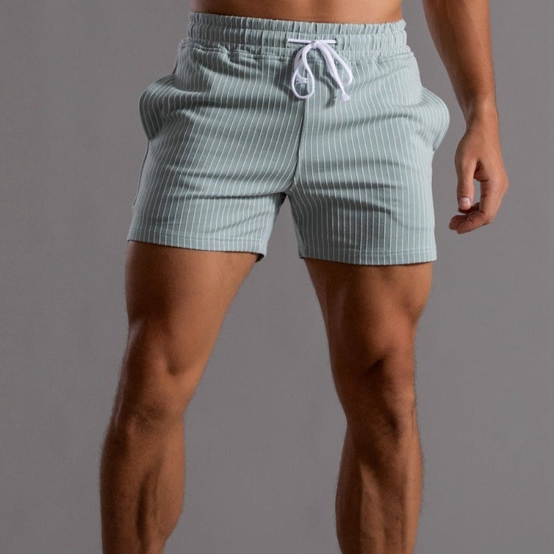 Short de bain rayé vert pour homme, taille élastique avec cordon blanc, style moderne et confortable, idéal pour la plage et la piscine.