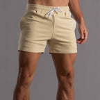Short de bain rayé beige pour homme avec cordon de serrage blanc, style moderne et confortable, idéal pour la plage et la piscine.