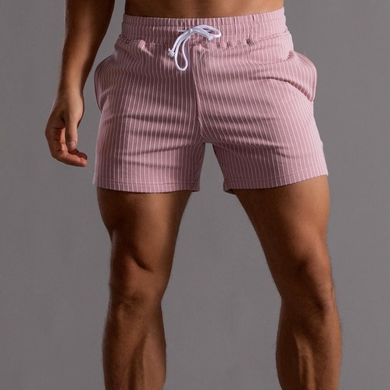 Short de bain rayé rose pour homme, taille élastique avec cordon, style moderne et ajusté, idéal pour la plage ou la piscine.