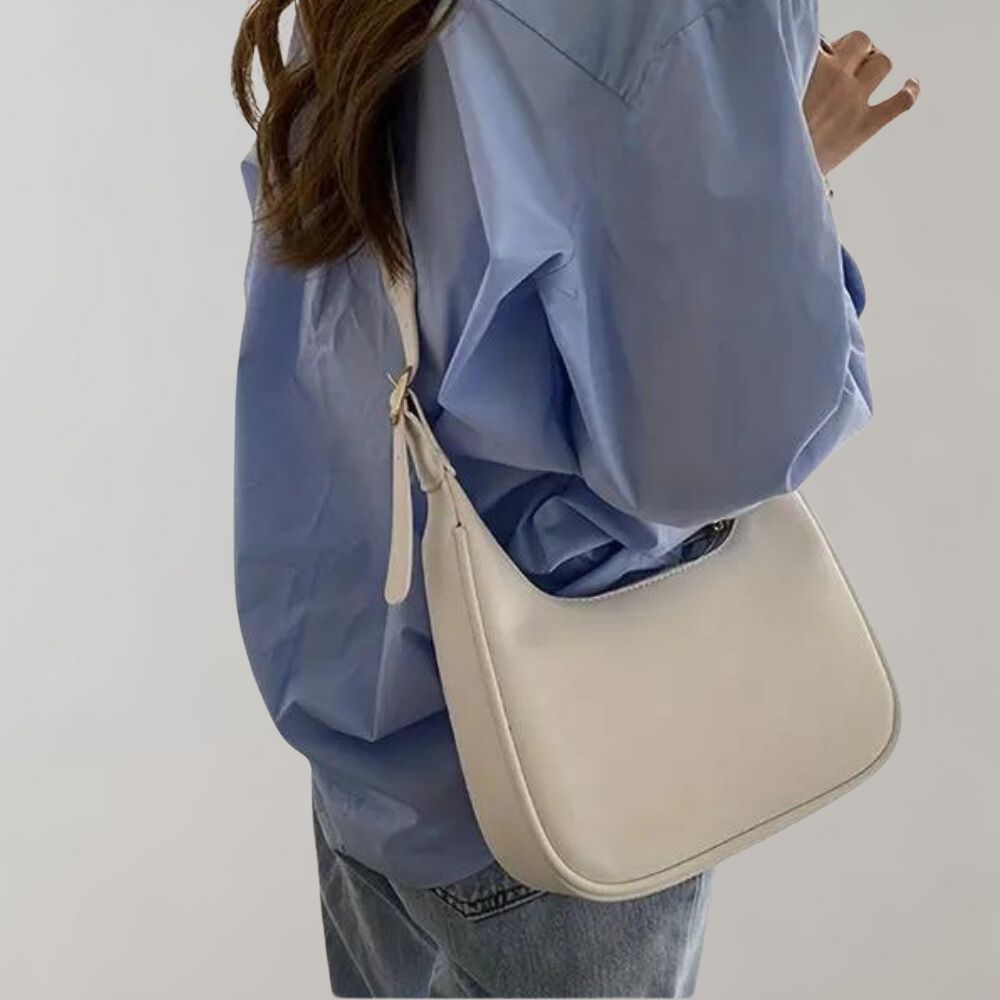 Femme portant une chemise bleue et un sac à main blanc élégant, mode décontractée, style moderne, accessoires tendance, tenue chic.