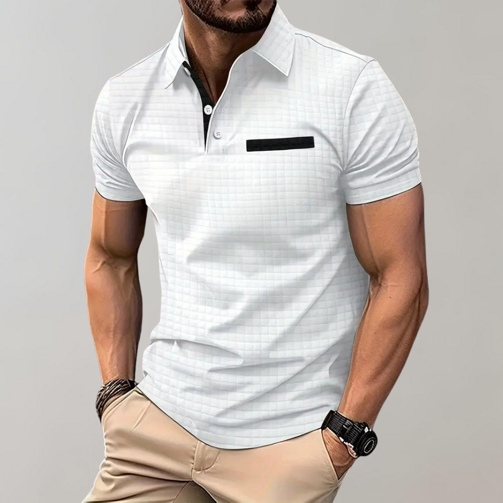 Homme portant un polo blanc élégant avec motif à carreaux, poche noire, montre noire, et pantalon beige. Mode masculine, style décontracté chic.