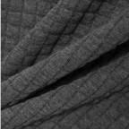 Tissu gris texturé en maille côtelée, motif quadrillé. Textile doux et épais, idéal pour vêtements d'hiver. Mode, confort, chaleur.