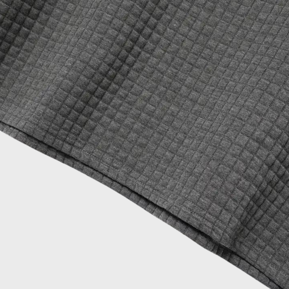 Tissu gris texturé en coton gaufré, motif à carreaux, fond blanc. Textile doux et élégant pour vêtements, décoration intérieure, couture.