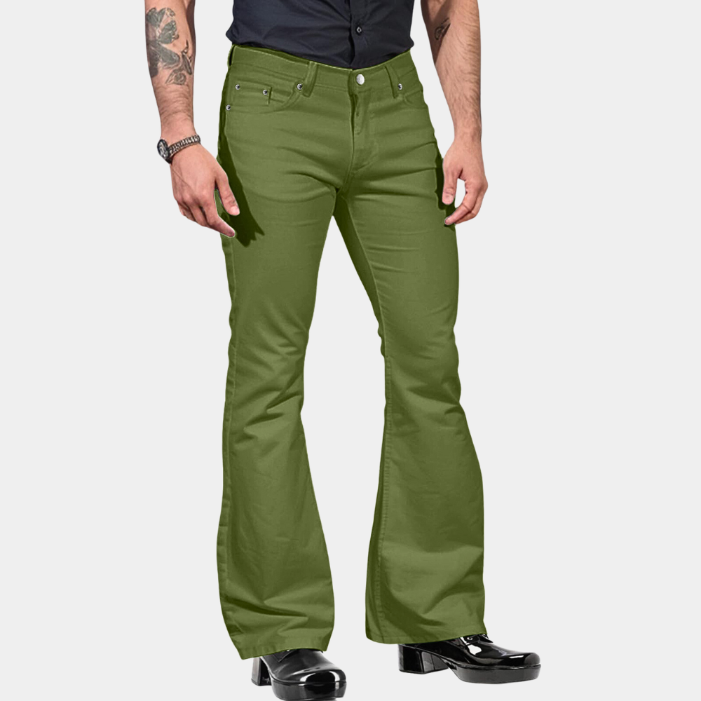 Homme portant un pantalon évasé vert olive, chemise noire et bottes noires. Mode rétro, style années 70, tendance vintage.