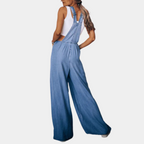 Femme portant une salopette en jean bleu, style décontracté, avec un débardeur blanc. Mode féminine tendance, tenue estivale chic.