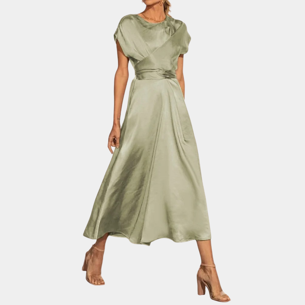 Robe longue en satin vert olive, manches courtes, ceinture nouée, portée avec des talons hauts beiges. Mode élégante et tendance pour femmes.