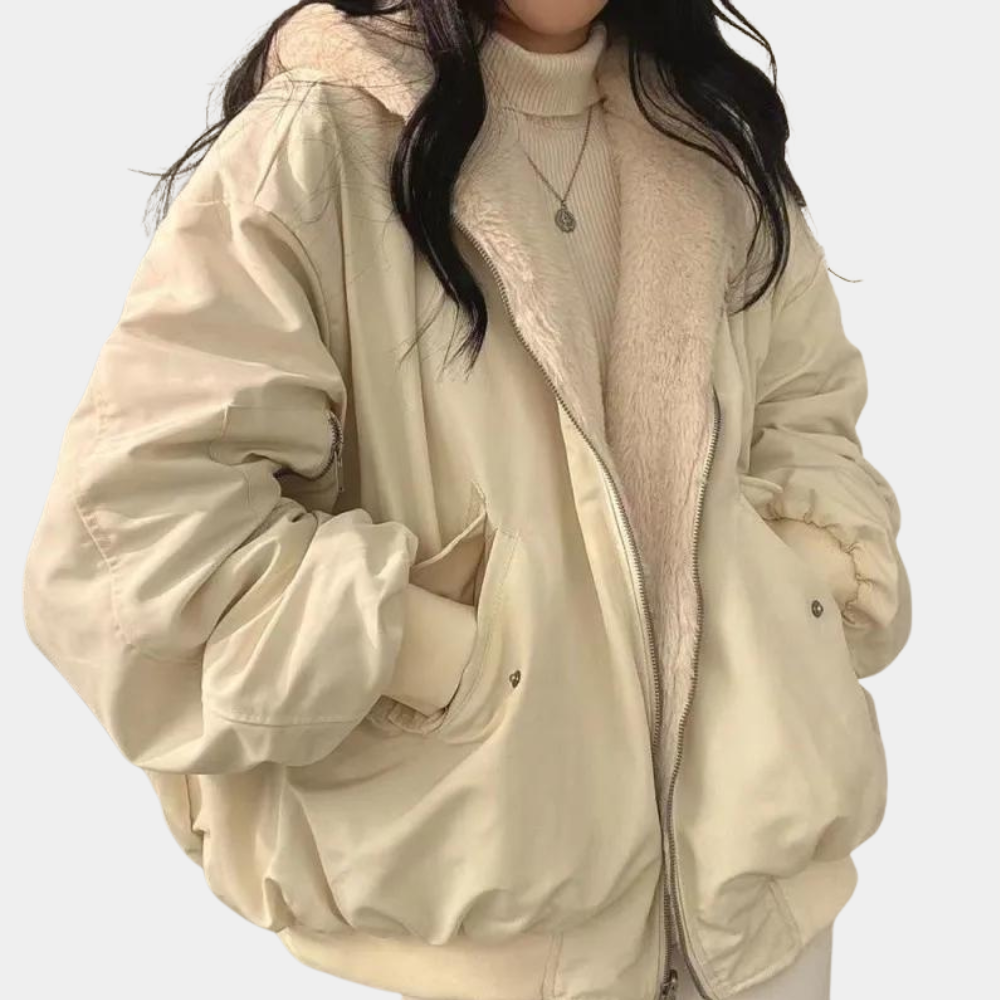 Veste beige oversize en tissu matelassé, doublure en fausse fourrure, portée par une femme. Mode hiver, tendance, confort, style décontracté.