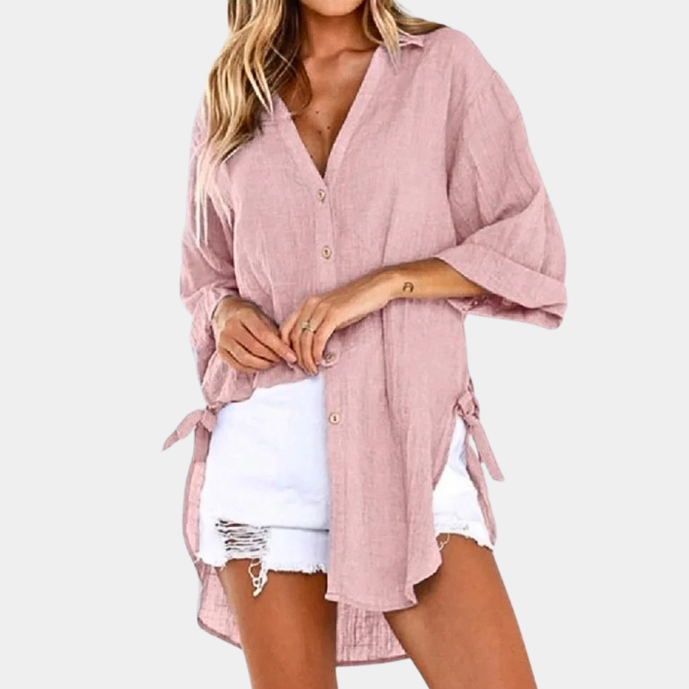 Femme portant une chemise rose ample en lin avec boutons, manches longues, associée à un short blanc déchiré. Mode décontractée estivale tendance.