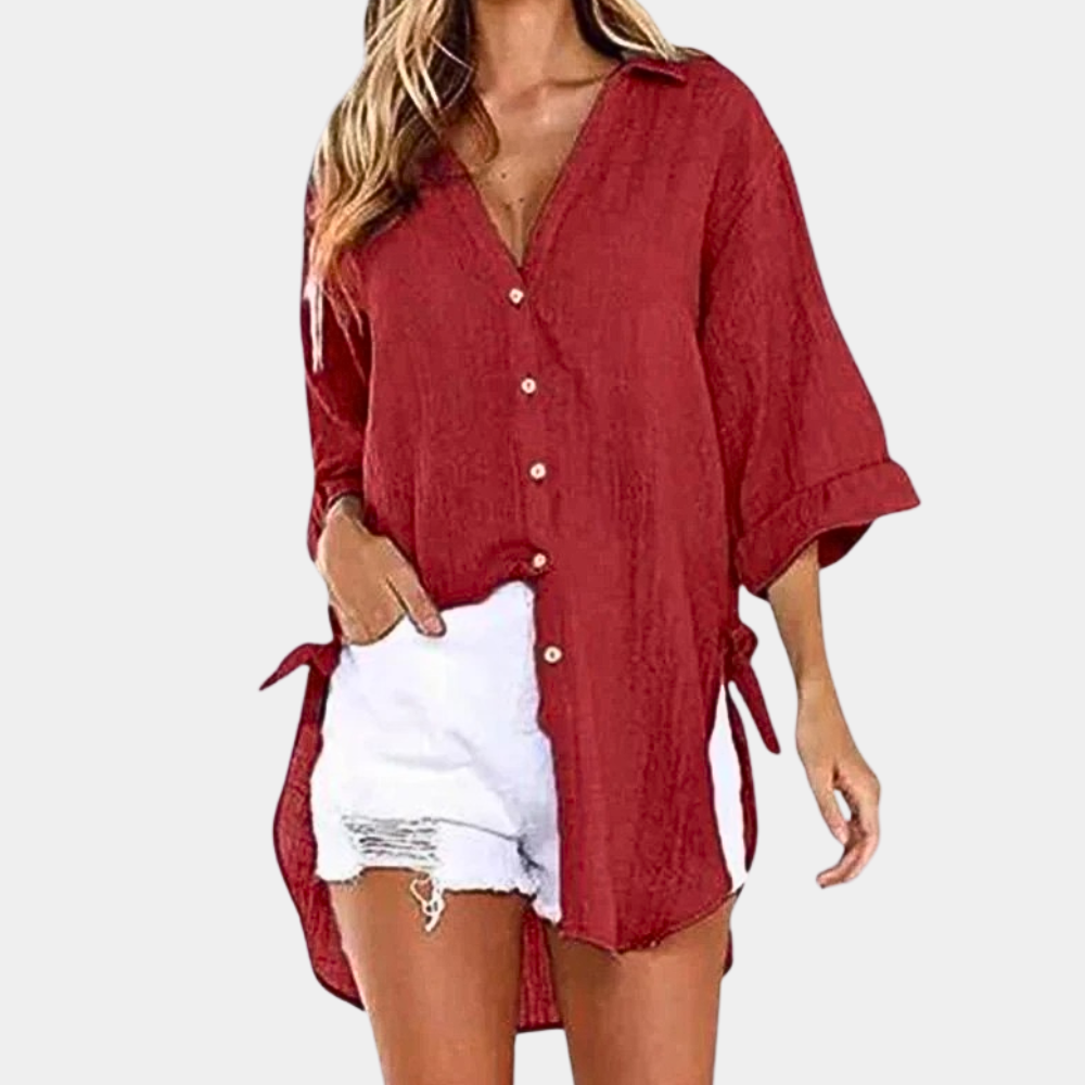 Chemise rouge ample pour femme, manches longues, col classique, boutons, associée à un short en jean blanc déchiré. Mode décontractée estivale.