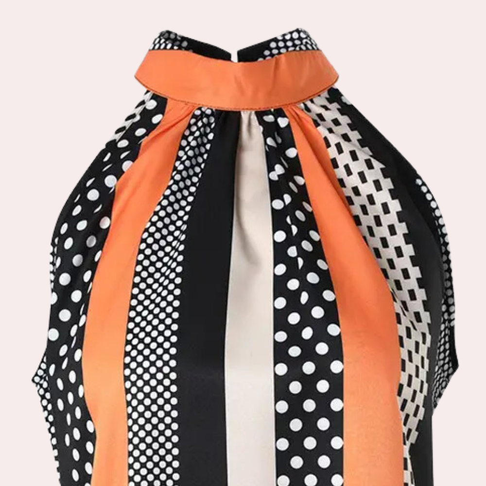 Haut sans manches à col montant, motif rayé et à pois noir, blanc et orange. Mode féminine élégante, tendance, chic.