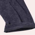 Pantalon en velours côtelé bleu marine, ourlet retroussé, tissu texturé, mode automne-hiver, vêtement élégant et confortable pour homme ou femme.