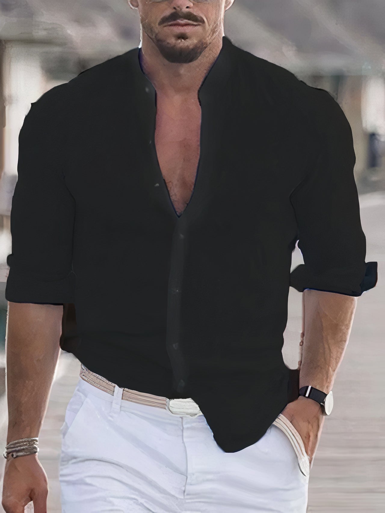 Homme en chemise noire élégante et pantalon blanc, montre-bracelet noire, marchant dans un cadre urbain moderne. Mode masculine chic et décontractée.