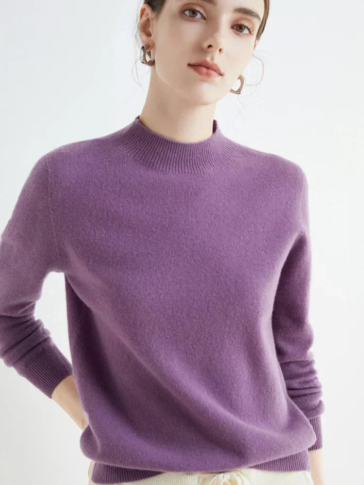 Femme portant un pull en cachemire violet, manches longues, col rond, style élégant et moderne, sur fond blanc. Mode féminine automne-hiver.