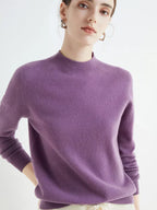 Femme portant un pull en cachemire violet, manches longues, col rond, style élégant et moderne, sur fond blanc. Mode féminine automne-hiver.