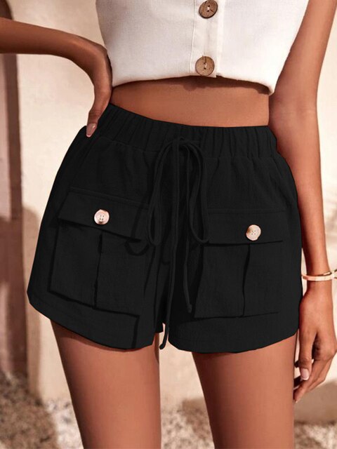 Femme portant un short noir taille haute avec poches et boutons, associé à un haut blanc sans manches. Mode estivale élégante et décontractée.