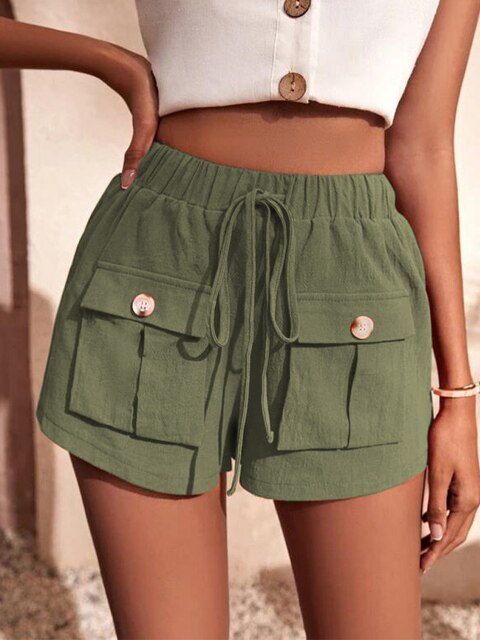 Femme portant un short vert kaki avec poches et cordon, haut blanc à boutons. Mode estivale décontractée, tenue tendance pour femme.