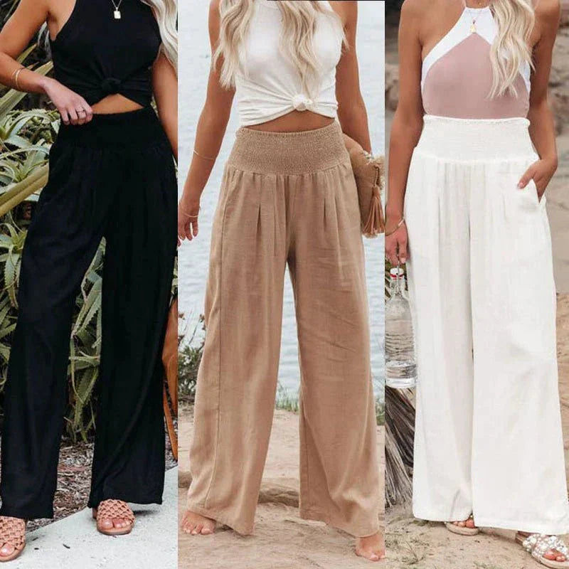 Trois femmes portant des pantalons larges et fluides en noir, beige et blanc, avec des hauts sans manches, sur fond extérieur. Mode estivale décontractée.