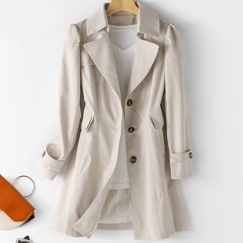 Trench-coat beige élégant pour femme sur cintre, avec chemise blanche en dessous. Mode automne, vêtement chic, style classique.