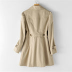 Trench-coat beige pour femme, élégant et classique, avec ceinture et boutons, suspendu sur un cintre. Mode automne, vêtement chic.