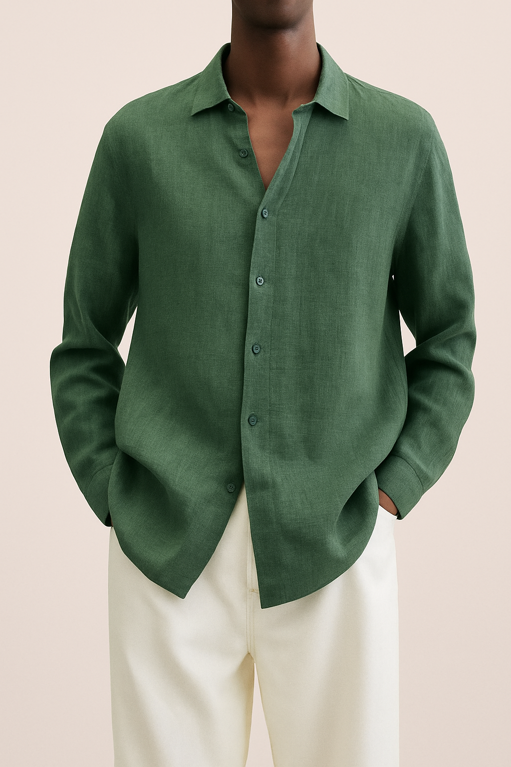 Homme portant une chemise verte en lin, manches longues, col ouvert, associée à un pantalon beige. Mode élégante et décontractée pour homme.