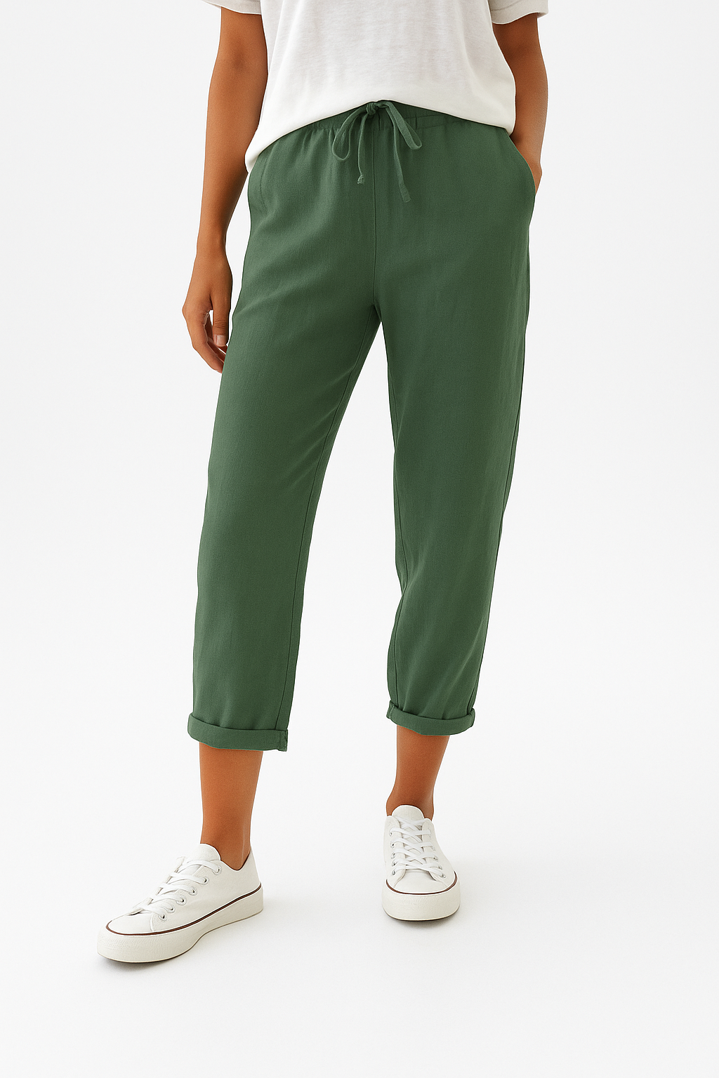 Pantalon vert décontracté pour femme, taille élastique avec cordon, ourlets retroussés, porté avec des baskets blanches et un t-shirt blanc.