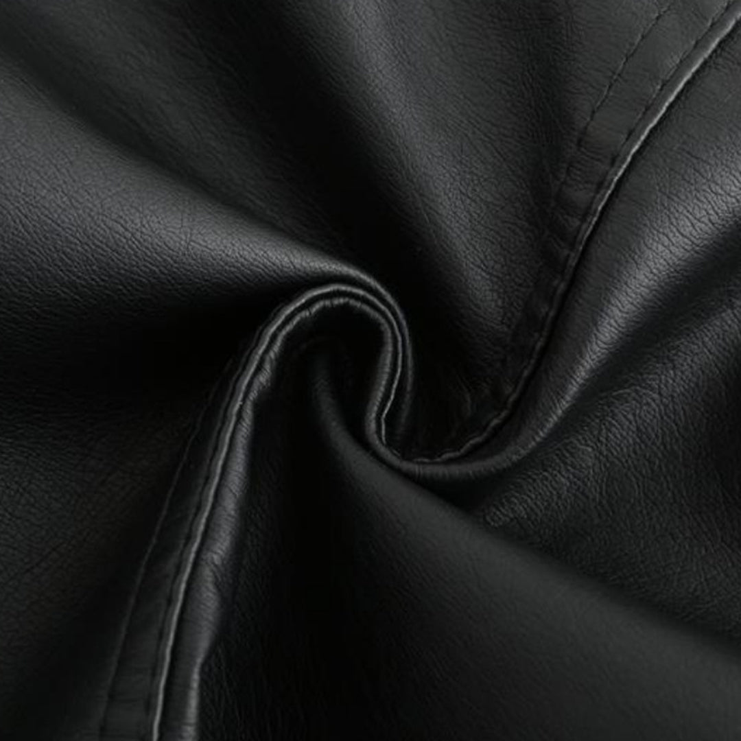 Texture de cuir noir, gros plan. Surface lisse et élégante, idéale pour vêtements, sacs ou meubles. Matériau durable et tendance.