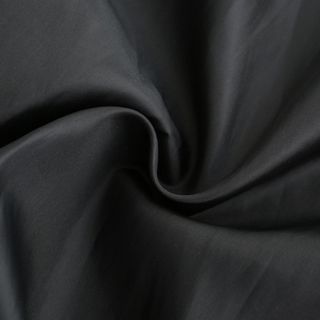 Tissu noir en coton, texture douce et lisse, idéal pour couture et mode. Matériau de haute qualité, parfait pour vêtements et décoration.