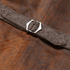 Ceinture en tissu marron avec boucle métallique sur fond en cuir brun, accessoire de mode élégant, style vintage, texture détaillée.