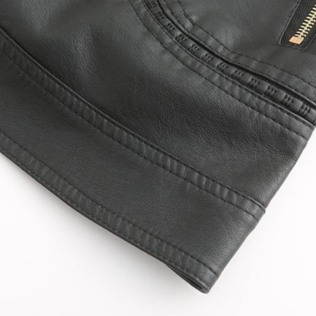 Veste en cuir noir avec fermeture éclair dorée, texture lisse et coutures détaillées, mode élégante et tendance pour homme ou femme.