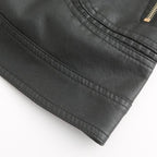 Veste en cuir noir avec fermeture éclair dorée, texture lisse et coutures détaillées, mode élégante et tendance pour homme ou femme.