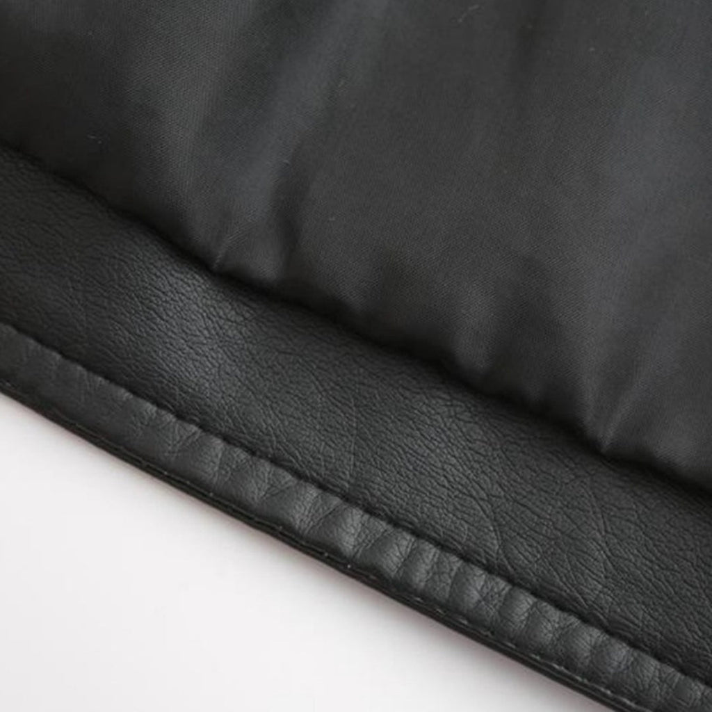 Gros plan d'un tissu noir en cuir synthétique et nylon, texture lisse et matelassée, idéal pour vêtements d'hiver ou accessoires de mode.