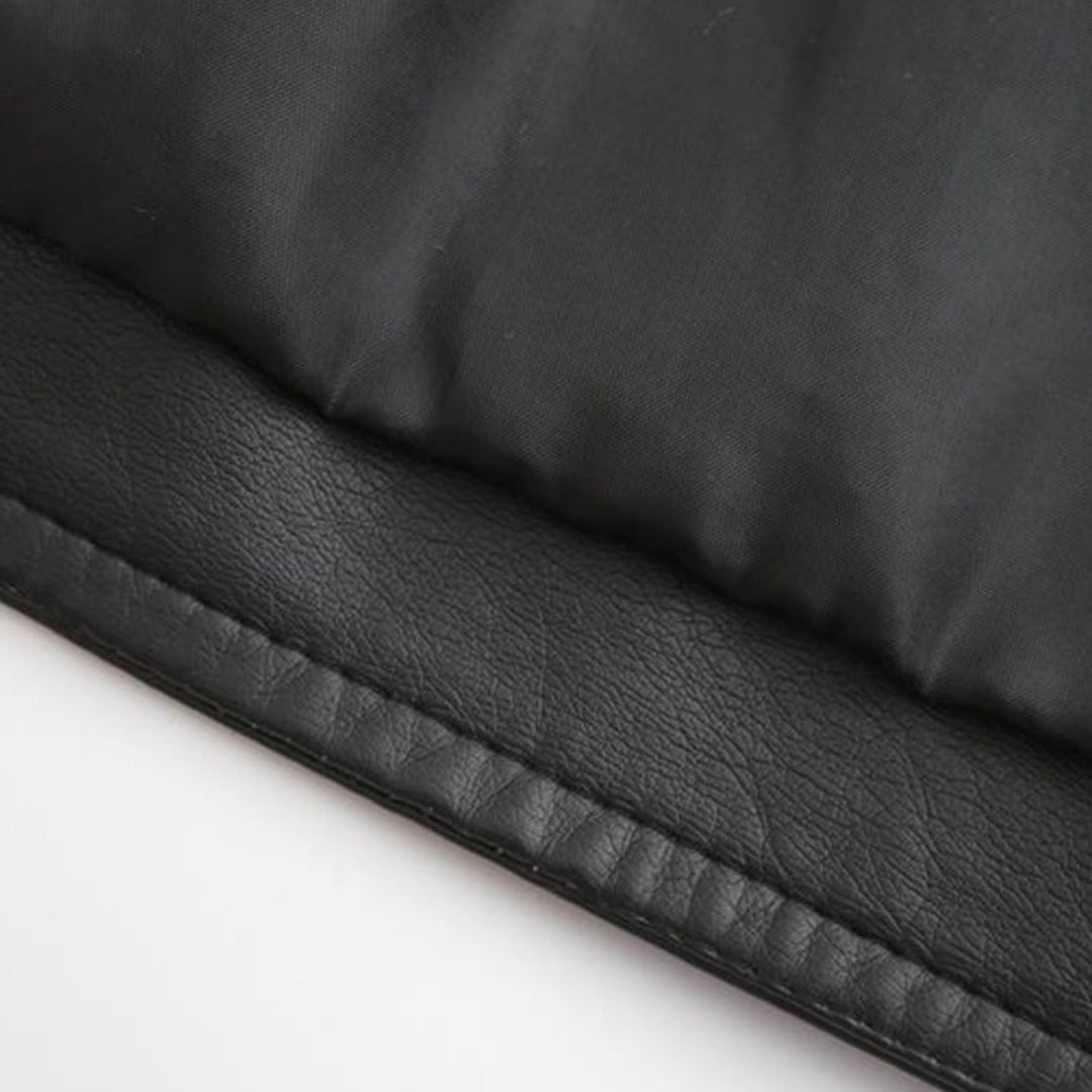 Gros plan d'un tissu noir en cuir synthétique et nylon, texture lisse et matelassée, idéal pour vêtements d'hiver ou accessoires de mode.