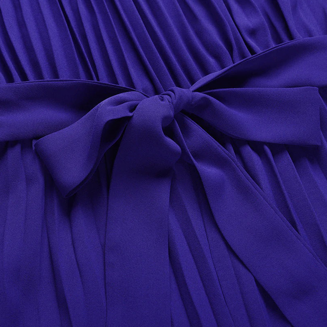 Robe plissée violette avec nœud élégant, tissu fluide et texture douce, mode féminine chic, tenue de soirée tendance.