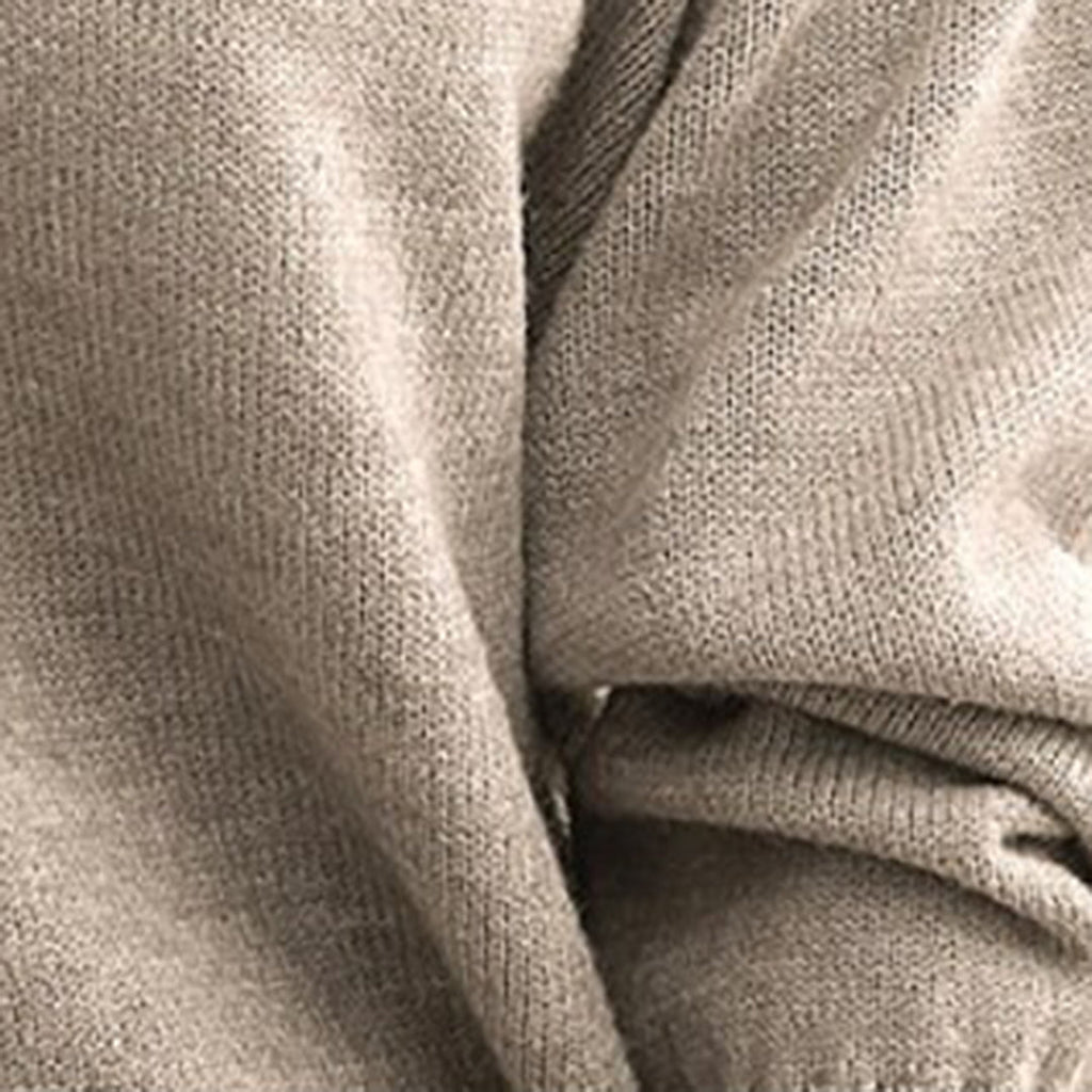 Gros plan d'un pull en laine beige, texture douce et tricotée, idéal pour l'hiver. Mode automne-hiver, vêtement chaud et confortable.