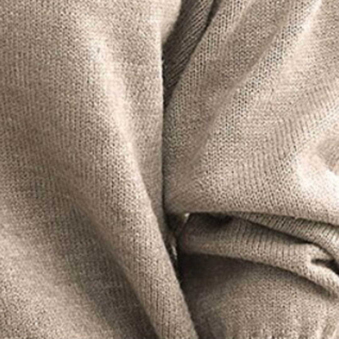 Gros plan d'un pull en laine beige, texture douce et tricotée, idéal pour l'hiver. Mode automne-hiver, vêtement chaud et confortable.