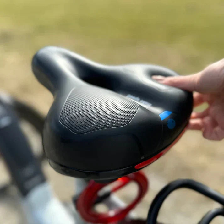 Selle de vélo ergonomique noire avec surface antidérapante, tenue par une main. Confort cycliste, accessoire vélo, design moderne.
