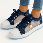 Baskets mode femme en dentelle transparente, bleu marine et blanc, avec pendentif doré, portées avec un jean. Chaussures tendance et élégantes.