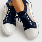 Chaussures de sport bleu marine à pois blancs, semelle blanche, lacets assortis, design moderne et tendance, vue de dessus.