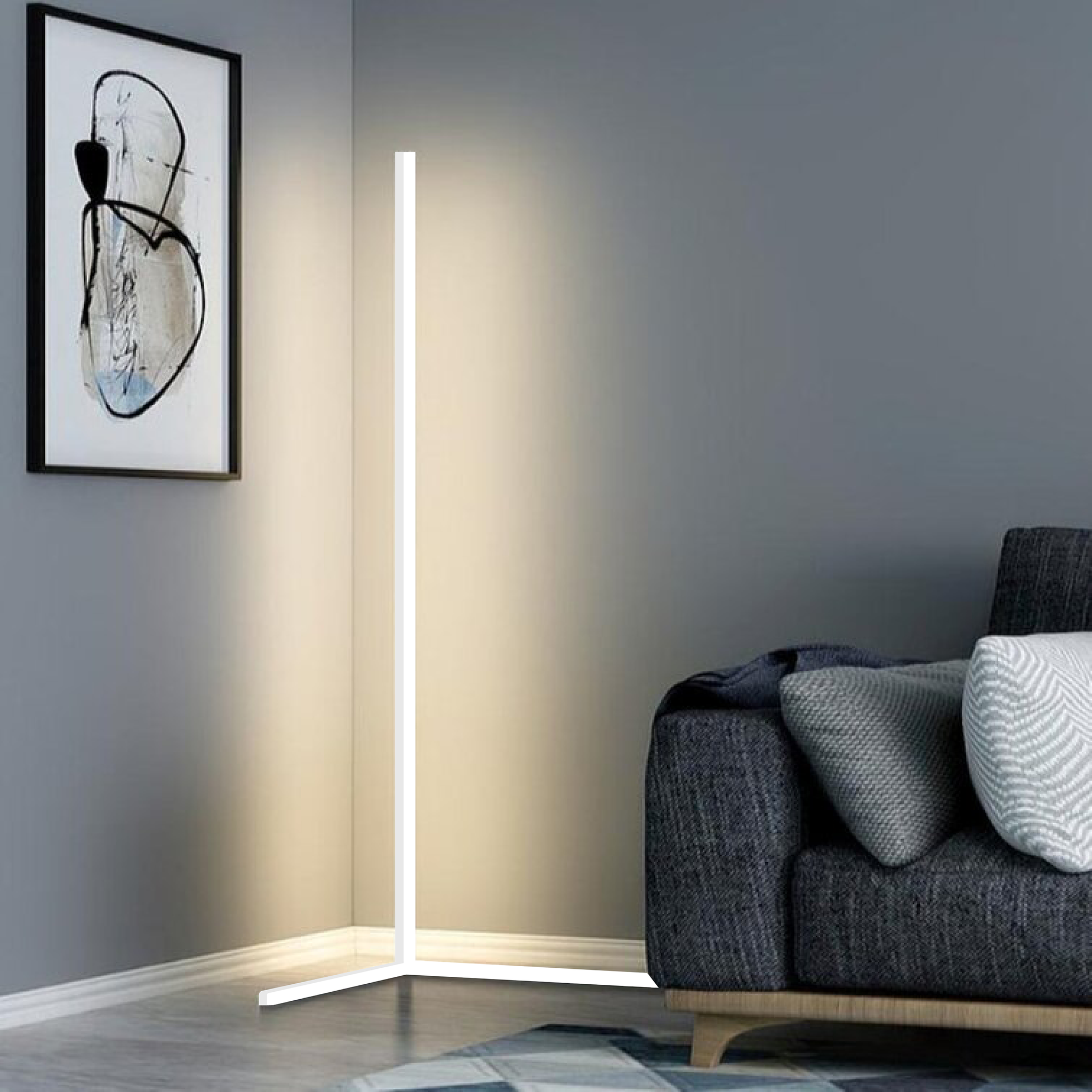 Lampe LED moderne en coin, éclairage d'ambiance minimaliste dans un salon élégant avec canapé gris et tableau abstrait sur mur gris.