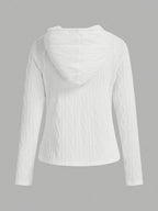 Veste à capuche blanche en tricot torsadé, manches longues, vue de dos. Mode femme, style décontracté, tendance automne-hiver.