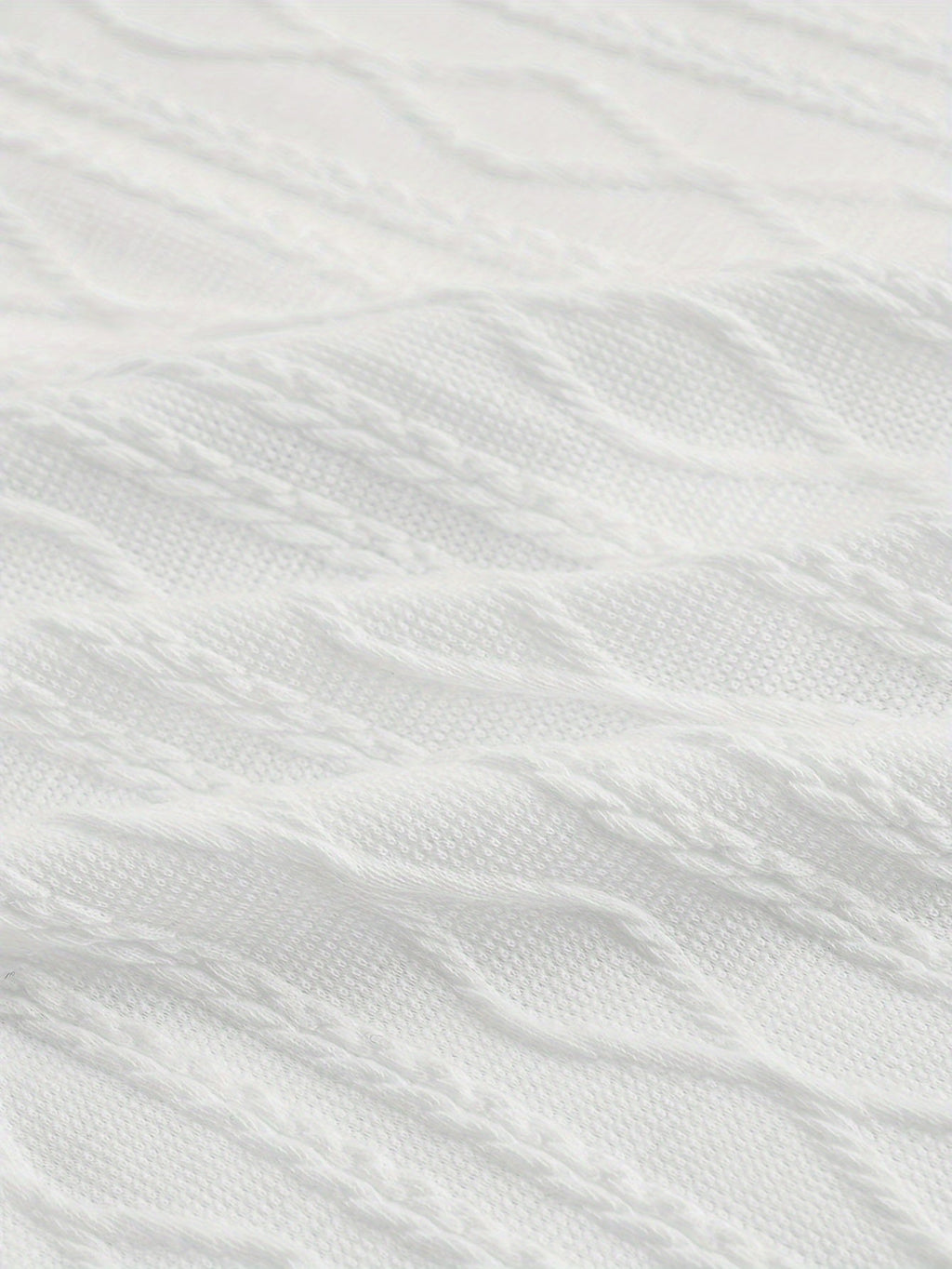 Texture de tissu en tricot torsadé blanc, motif géométrique. Idéal pour mode hiver, vêtements chauds, pulls élégants.