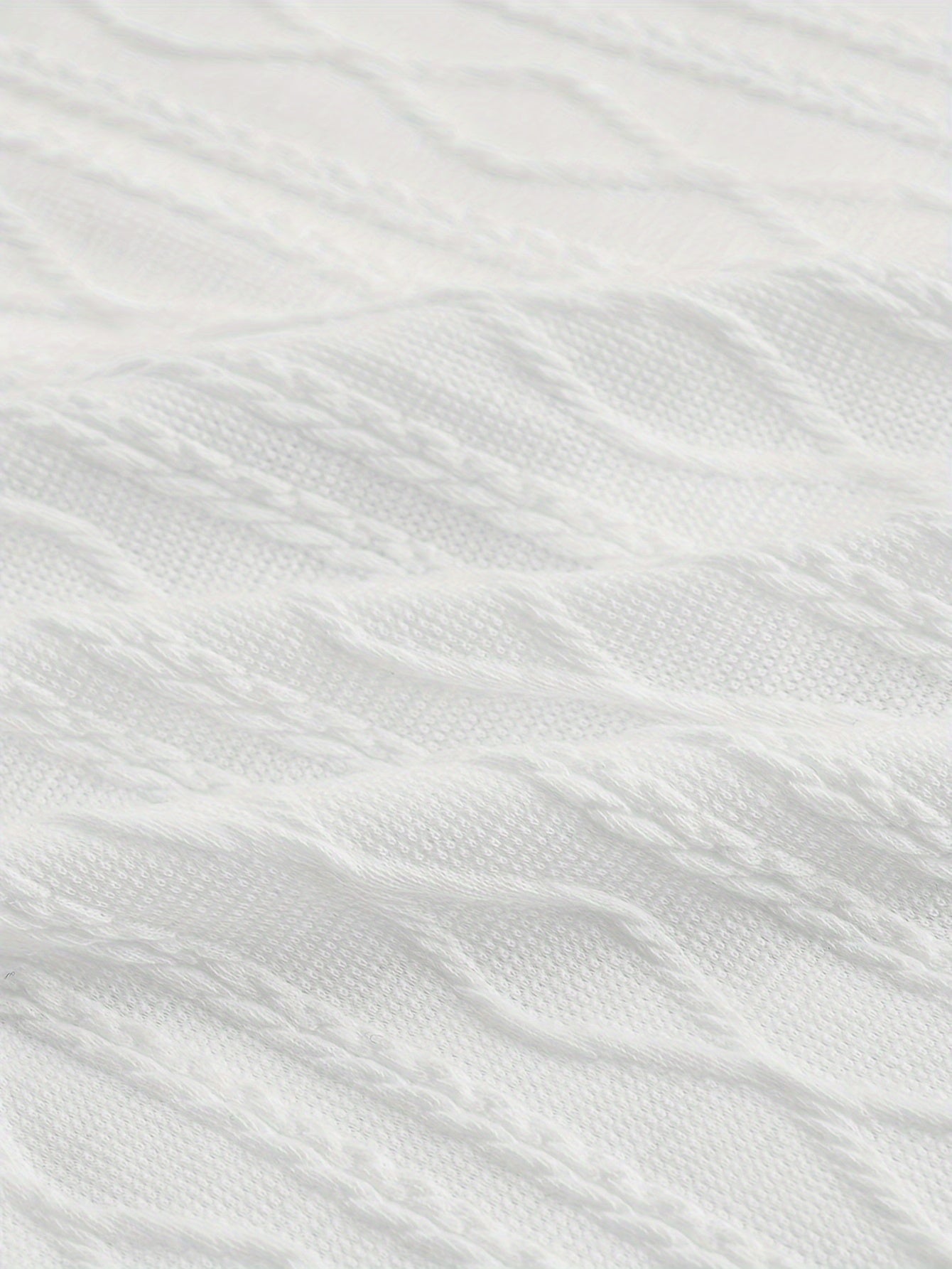 Texture de tissu en tricot torsadé blanc, motif géométrique. Idéal pour mode hiver, vêtements chauds, pulls élégants.