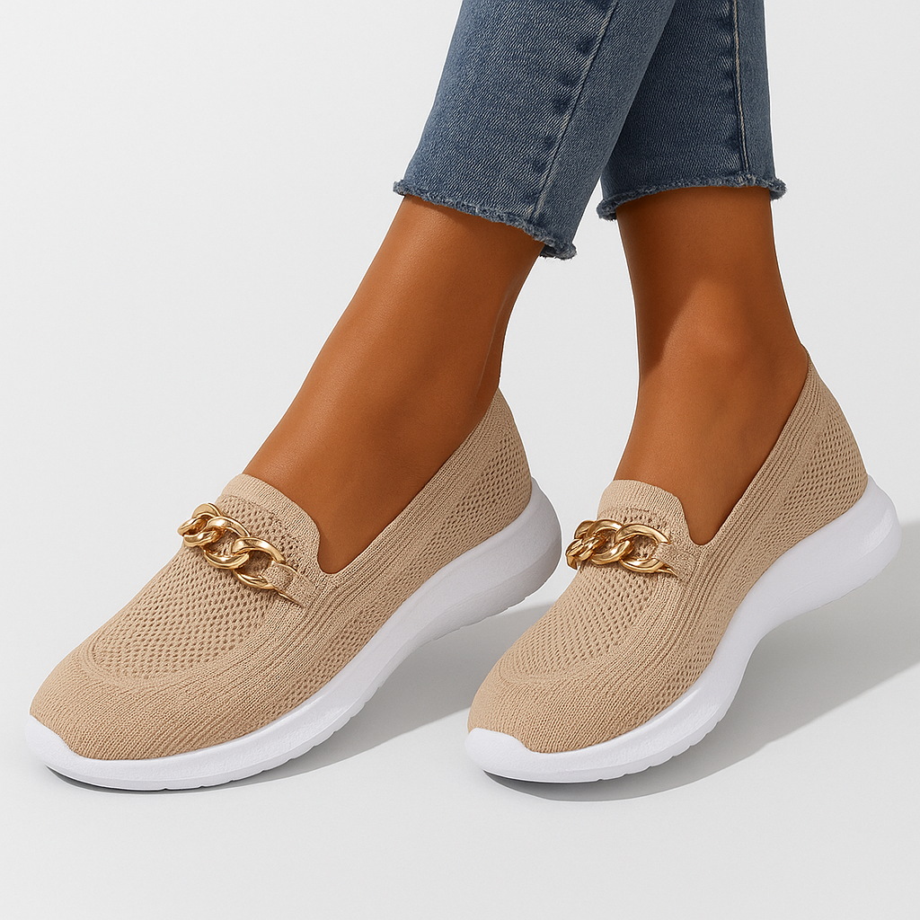 Chaussures beiges en maille avec chaîne dorée, semelle blanche épaisse, portées avec un jean. Style moderne et confortable pour femme.