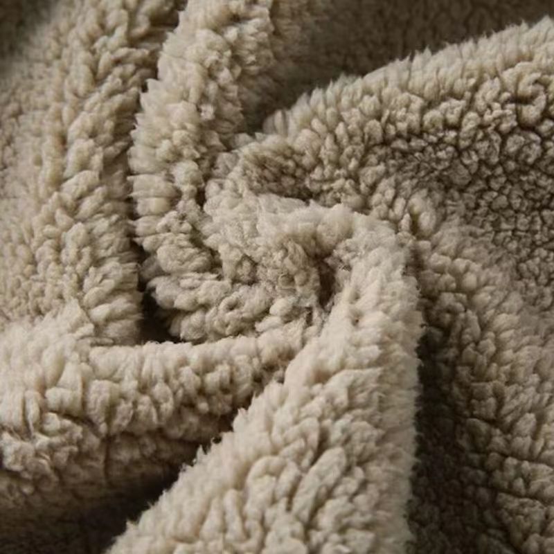 Tissu polaire beige doux et moelleux, texture en peluche, idéal pour couvertures chaudes et vêtements d'hiver confortables.
