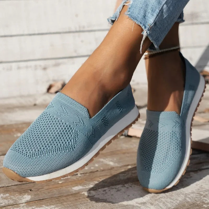 Chaussures en toile bleue pour femme, style décontracté, avec semelle blanche antidérapante, portées avec un jean effiloché. Mode estivale tendance.