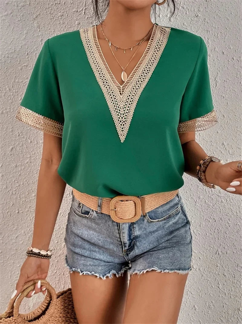 Femme portant un haut vert à col en V avec dentelle, short en jean, ceinture beige, et accessoires. Mode estivale chic et décontractée.
