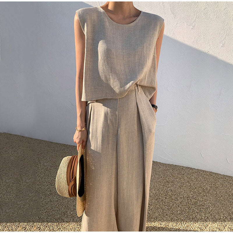 Femme en tenue d'été beige élégante, portant un chapeau de paille. Mode minimaliste, style décontracté chic, vêtements en lin.