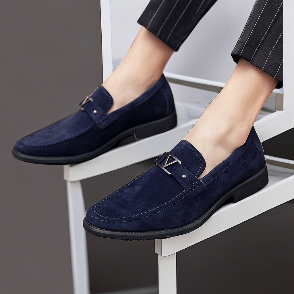 Chaussures mocassins en daim bleu marine pour homme, élégantes et modernes, portées avec un pantalon à rayures. Mode masculine, style chic.