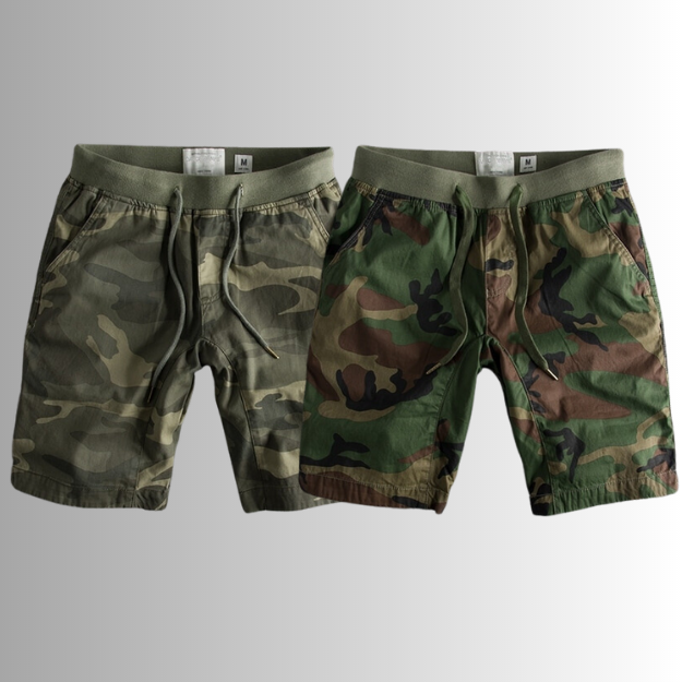 Deux shorts camouflage pour homme, style militaire, avec cordon de serrage, motifs verts et marron, sur fond dégradé gris.