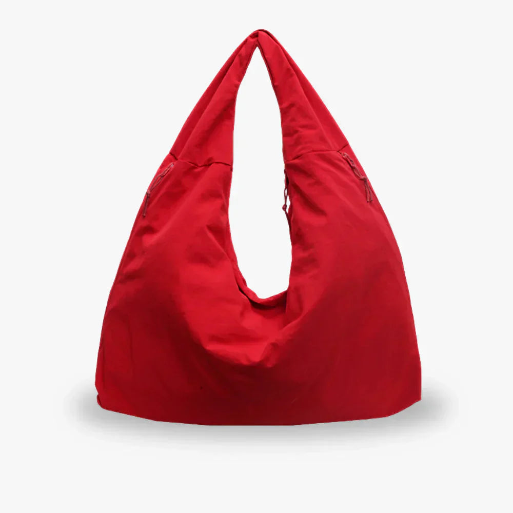 Sac à main rouge en tissu, design moderne et minimaliste, avec deux poches zippées. Accessoire de mode tendance pour femme.